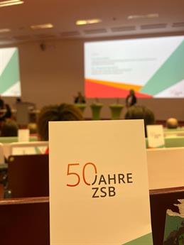 View of one of the flyers displayed in the rows of seats in the lecture hall at the 50th anniversary celebration